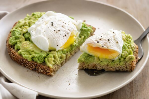 Servierszene mit dem fertigen Gericht. Rezept: Avocado-Brot mit pochiertem Ei