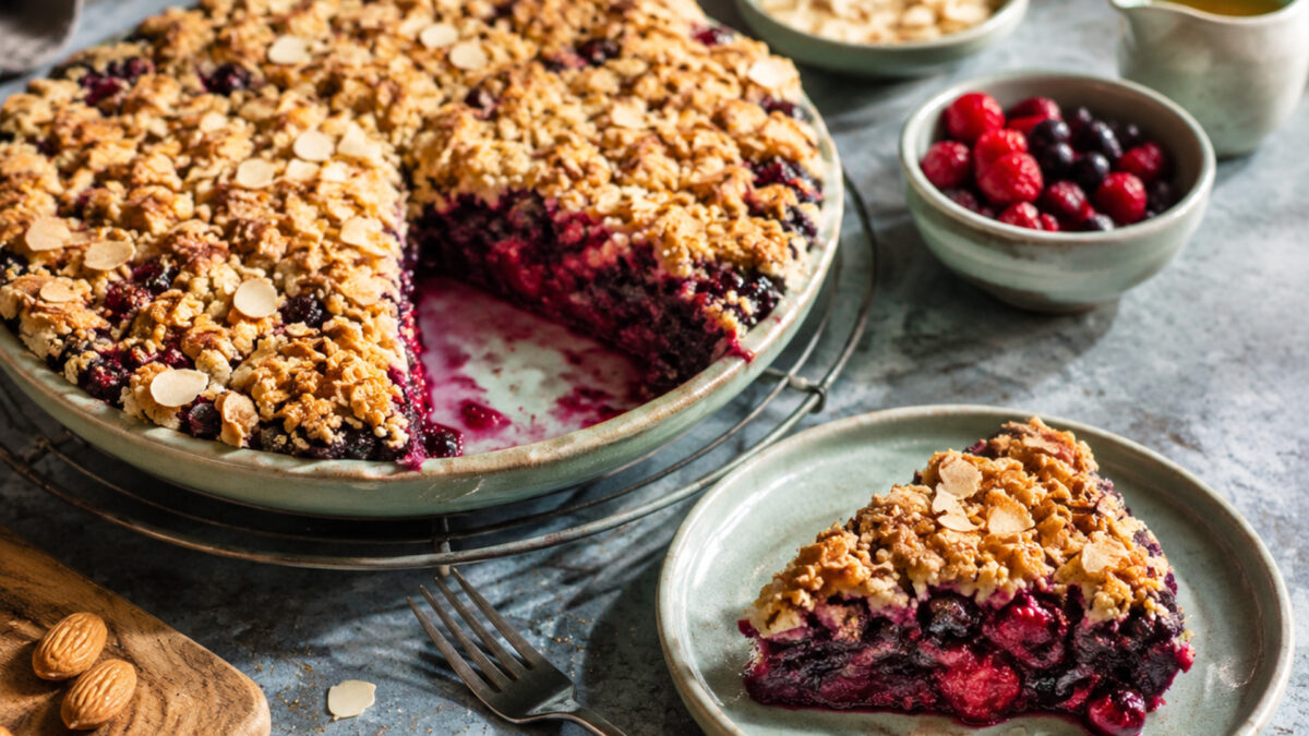 Servierszene mit dem fertigen Gericht. Rezept: Beeren-Crumble mit Mandelstreuseln