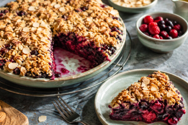 Servierszene mit dem fertigen Gericht. Rezept: Beeren-Crumble mit Mandelstreuseln