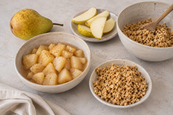 Zutaten- und Vorbereitungsansicht mit Birnenkompott, Birnenspalten und vorbereitetem Hafer-Crumble.