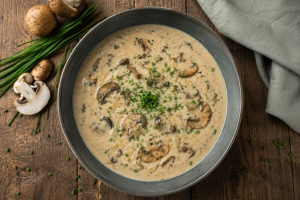 Fertige Champignon-Lauch-Suppe in Draufsicht mit sichtbaren Champignonscheiben und Schnittlauch.