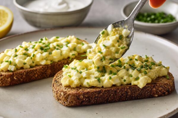 Servierszene mit dem fertigen Gericht. Rezept: Eiersalat mit Schnittlauch auf Vollkornbrot