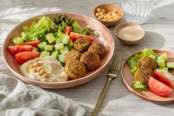 Servierszene mit dem fertigen Gericht. Rezept: Falafel mit Tahini-Dip und Salat