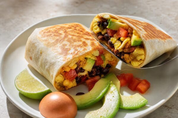 Servierszene mit dem fertigen Gericht. Rezept: Frühstücks-Burrito mit Ei, Bohnen und Avocado