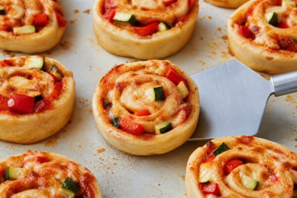 Servierszene mit dem fertigen Gericht. Rezept: Gefüllte Pizzaschnecken mit Gemüse