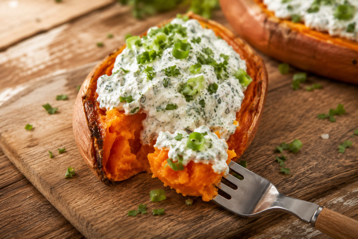 Servier- und Detailansicht einer gefüllten Süßkartoffel mit Kräuterquark und einer Portion auf der Gabel.