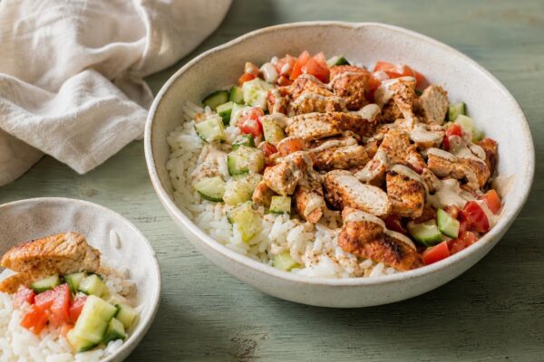 Servierszene mit dem fertigen Gericht. Rezept: Hähnchen-Shawarma-Bowl mit Reis und Salat
