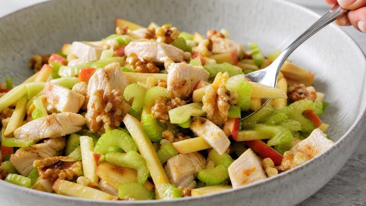 Servierszene mit dem fertigen Gericht. Rezept: Hähnchensalat mit Apfel, Sellerie und Walnüssen