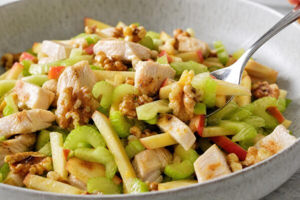 Servierszene mit dem fertigen Gericht. Rezept: Hähnchensalat mit Apfel, Sellerie und Walnüssen