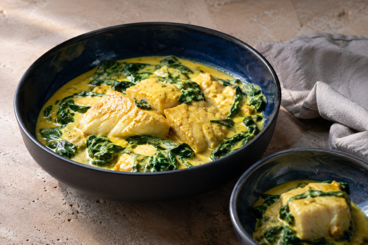 Servierszene mit dem fertigen Gericht. Rezept: Kabeljau-Curry mit Kokosmilch und Spinat