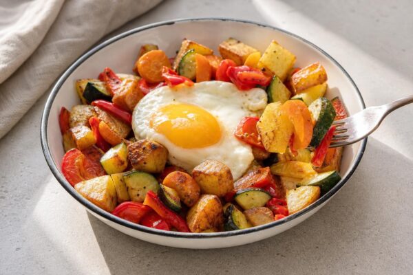Servierszene mit dem fertigen Gericht. Rezept: Kartoffel-Gemüse-Pfanne mit Spiegelei