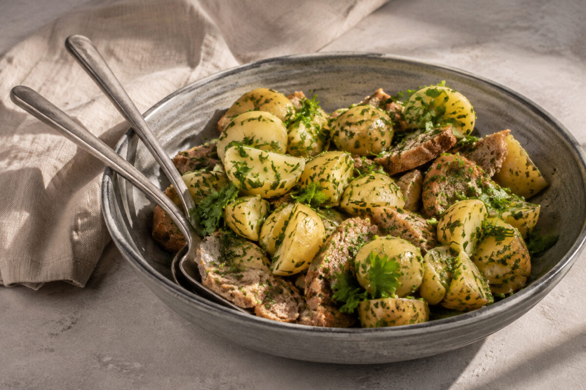 Servierszene mit dem fertigen Gericht. Rezept: Kartoffel-Kräuter-Salat auf Vollkornbrot