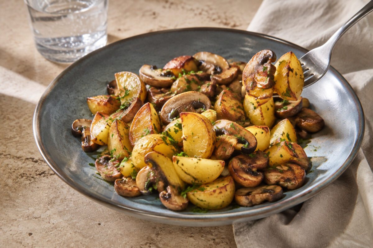 Servierszene mit dem fertigen Gericht. Rezept: Kartoffel-Pilz-Pfanne mit Kräutern