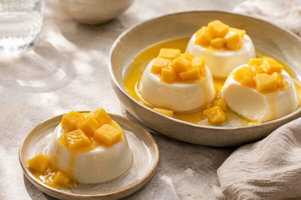 Servierszene mit dem fertigen Gericht. Rezept: Kokos-Panna-Cotta mit Mango