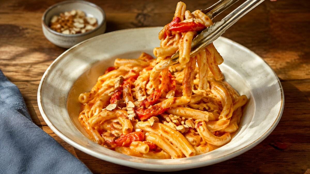 Servierszene mit dem fertigen Gericht. Rezept: Pasta mit Paprika-Mandel-Sauce