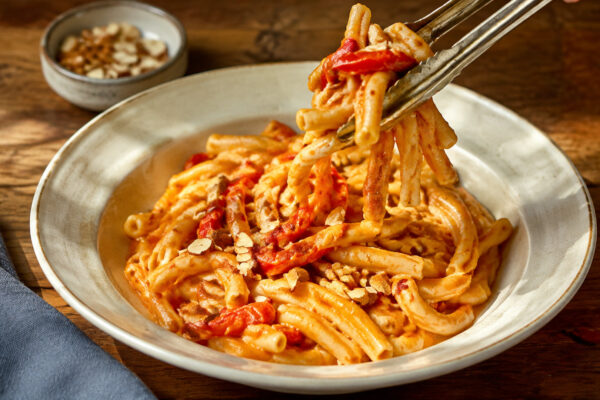 Servierszene mit dem fertigen Gericht. Rezept: Pasta mit Paprika-Mandel-Sauce