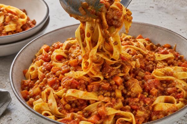 Servierszene mit dem fertigen Gericht. Rezept: Pasta mit Tomaten-Linsen-Bolognese