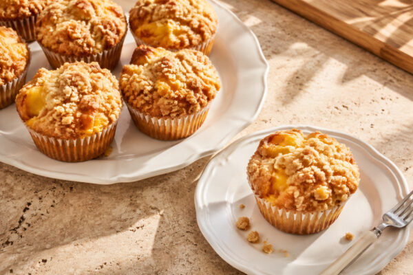 Servierszene mit dem fertigen Gericht. Rezept: Pfirsich-Streusel-Muffins