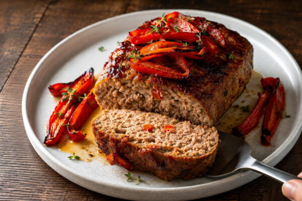 Nahe Servieransicht des angeschnittenen Putenhackbratens mit gerösteter Paprika.
