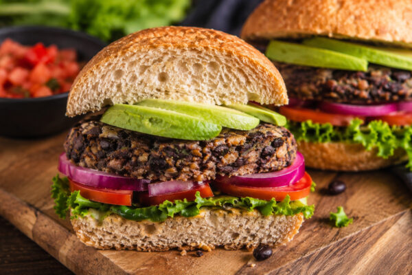 Nahe Servieransicht des fertigen Schwarze-Bohnen-Burgers mit Avocado.