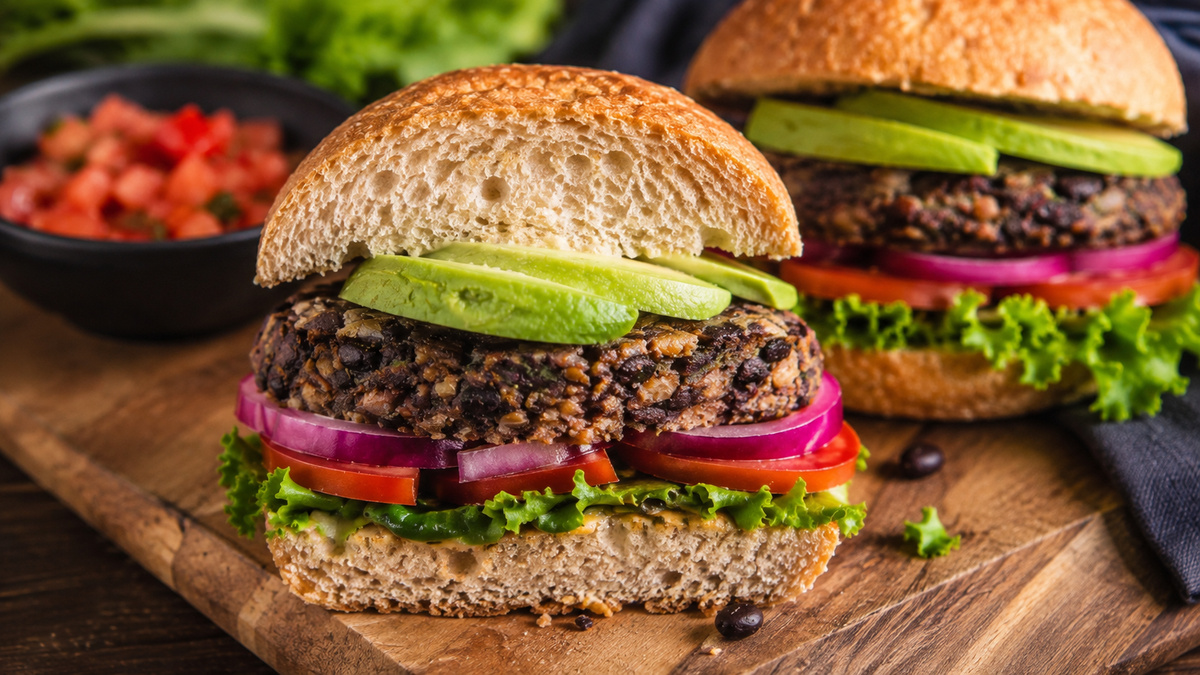 Nahe Servieransicht des fertigen Schwarze-Bohnen-Burgers mit Avocado.