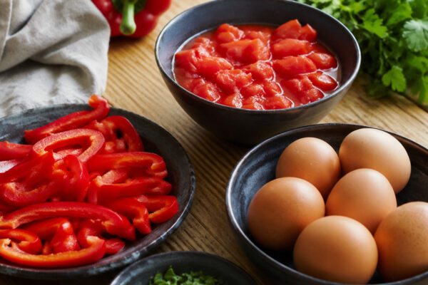 Zutaten- und Vorbereitungsansicht. Rezept: Shakshuka mit Paprika und Kräutern