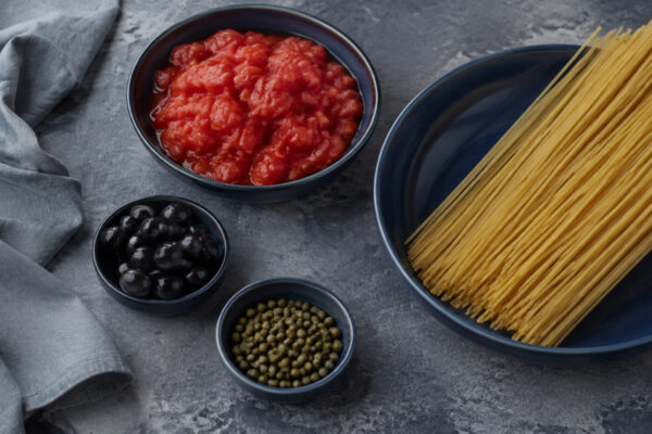 Zutaten- und Vorbereitungsansicht. Rezept: Spaghetti mit Tomaten, Oliven und Kapern