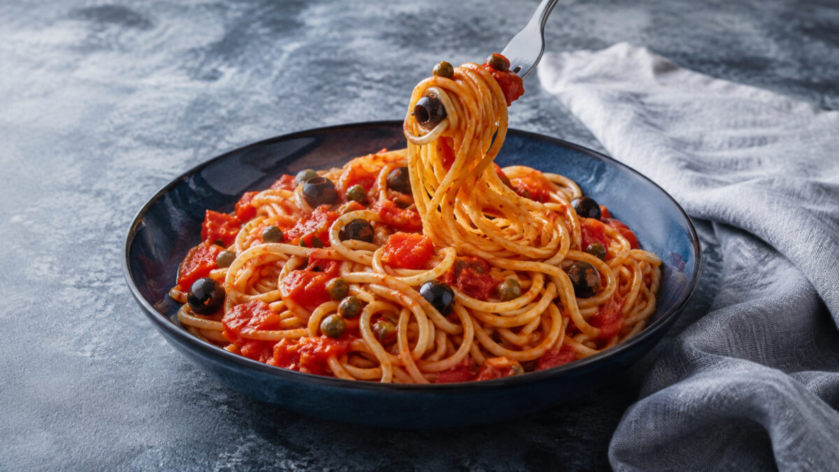 Servierszene mit dem fertigen Gericht. Rezept: Spaghetti mit Tomaten, Oliven und Kapern
