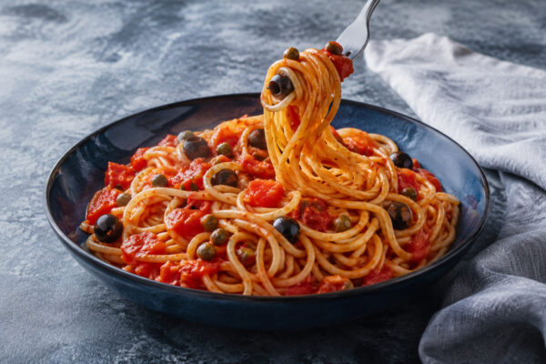 Servierszene mit dem fertigen Gericht. Rezept: Spaghetti mit Tomaten, Oliven und Kapern