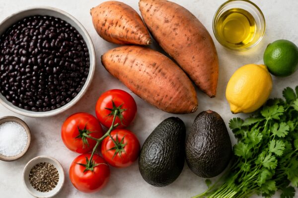Übersicht aller Zutaten für „Süßkartoffel-Bohnen-Bowl mit Avocado“ auf heller Arbeitsfläche, sauber gruppiert, ohne Verpackungsschrift und ohne fertiges Gericht.