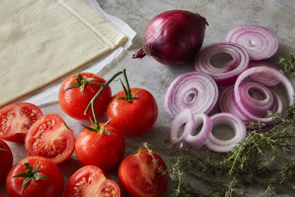 Zutaten- und Vorbereitungsansicht. Rezept: Tomaten-Zwiebel-Tarte mit Kräutern
