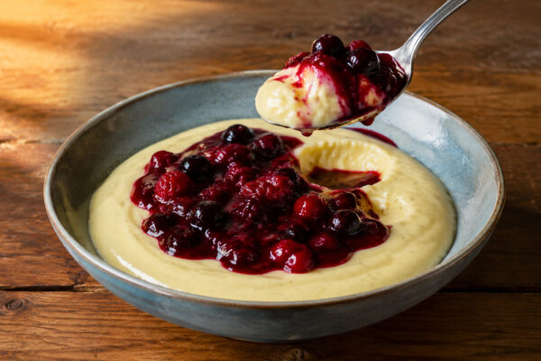 Servierszene mit dem fertigen Gericht. Rezept: Vanillepudding mit Beerenkompott